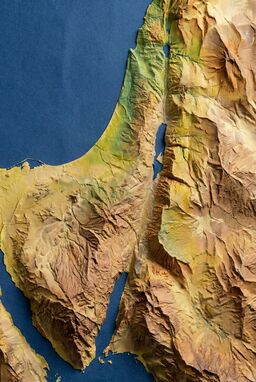  A map where terrain is suggested by the wrinkles, folds, and shadows of crumpled color paper that reflects the landcover—abstract but readable, rugged and raw.