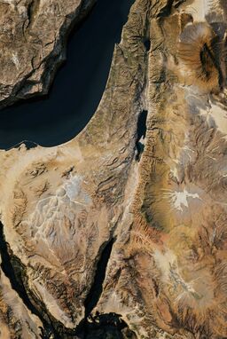  A map where terrain features are rendered as if carved into ancient, weather-worn stone — deep cracks for valleys, rough surfaces for hills, smooth plates for plains. Naturalistic and rugged.