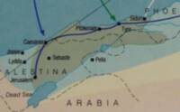 Flat atlas style with muted pastel region fills, cyan hydrography, dashed internal boundaries, black settlement symbols, and overprinted blue and green directional route arrows.