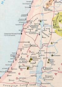 The map uses flat pastel regional fills, pale blue water, red administrative boundary lines, and dense black italic settlement labeling with dot, cross, and yellow-highlighted city symbols.
